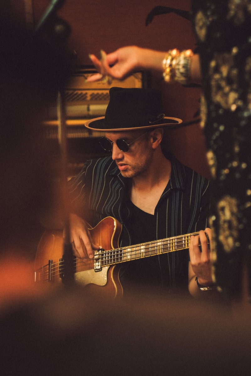 Bassist in fedora and sunglasses, hollowbody guitar