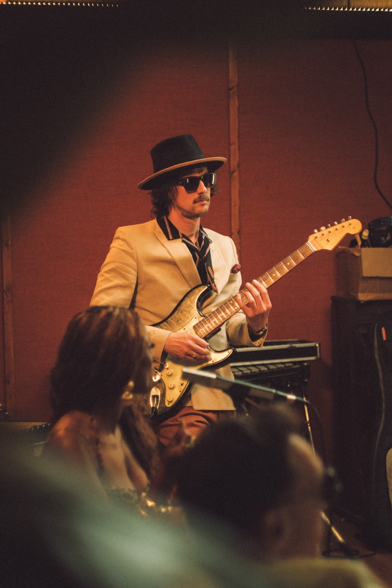 Guitarist in cream suit with Stratocaster
