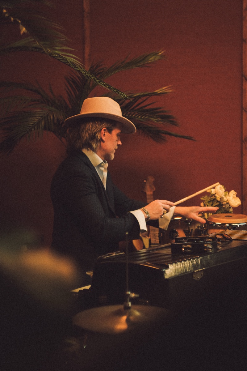 Keys player in dark suit with drumsticks